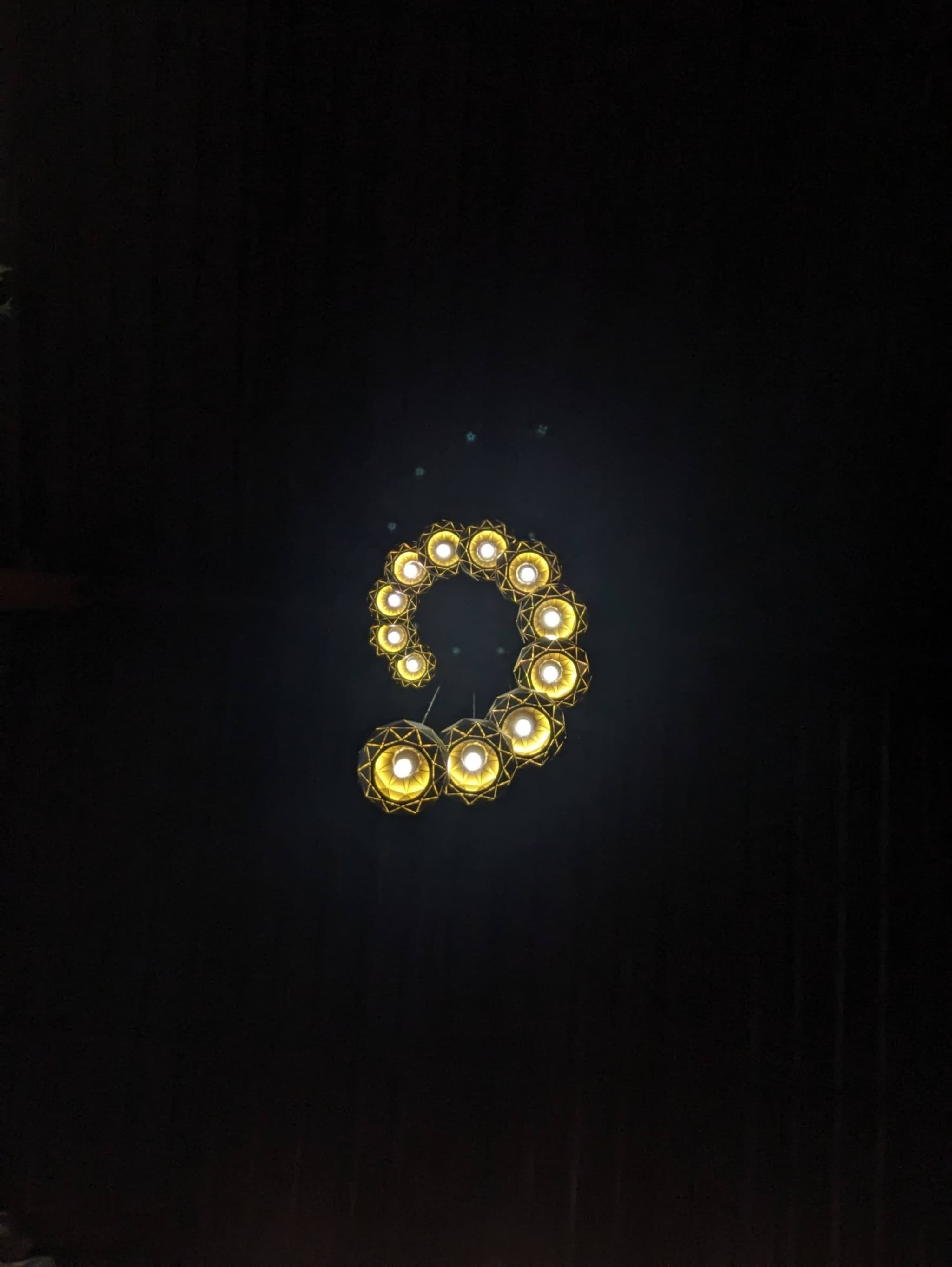 A formation of illuminated lights shaped like the number nine against a dark background